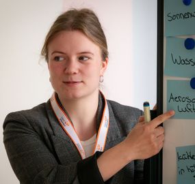 Trainerin zeigt auf Flipchart.