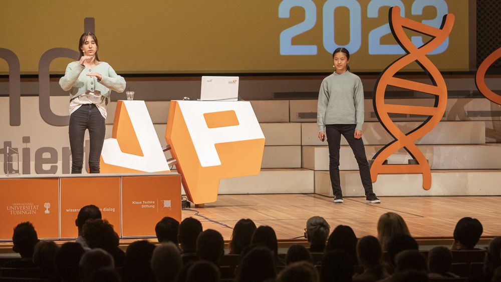 Zwei Schülerinnen präsentieren auf der Bühne beim Finale.