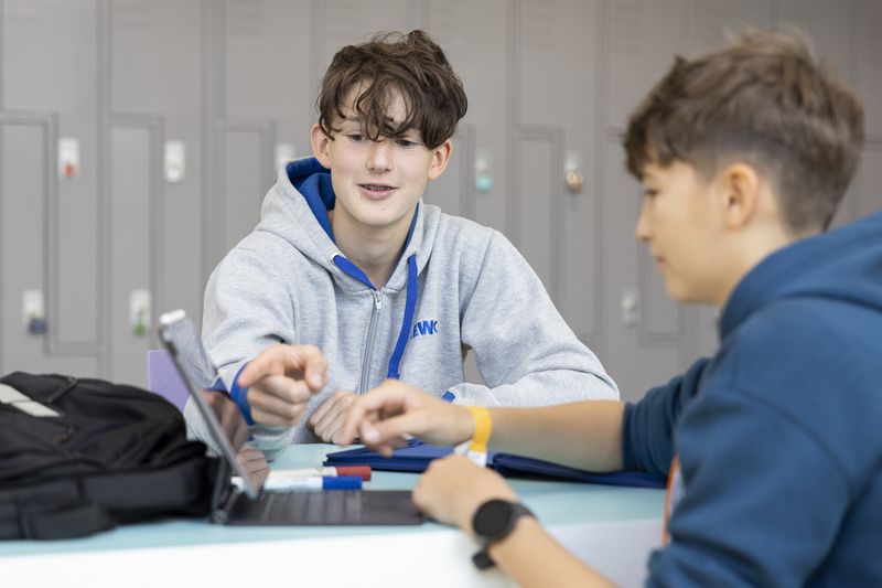 Schüler*innen bereiten sich auf ihre Präsentation vor und besprechen sich.