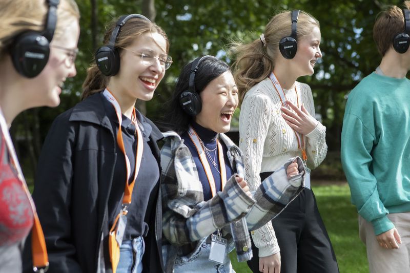 Eine Gruppe Schülerinnen nimmt am Radiobalett teil und trägt währenddessen Kopfhörer und lacht.