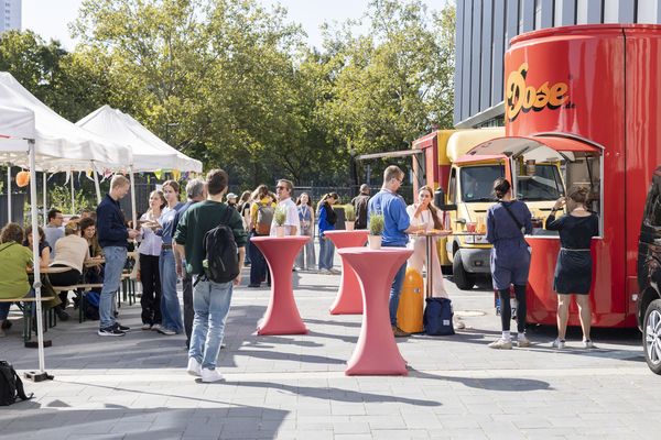 Foodtrucks und Pavillons mit Stehtischen im Schulhof.
