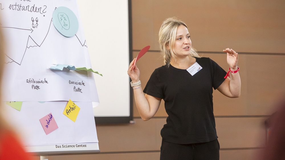 Lehrerin erklärt vor einer Flipchart beim Training