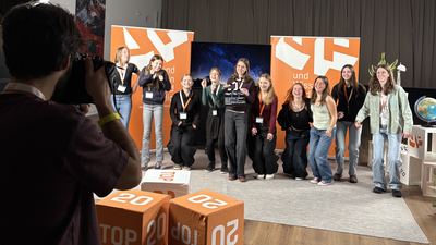 Teilnehmerinnen beim Top-20-Dreh springen in die Luft und machen ein Gruppenfoto.