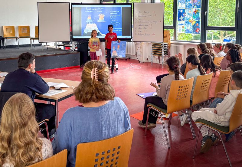 Grundschüler*innen präsentieren vor einem Publikum