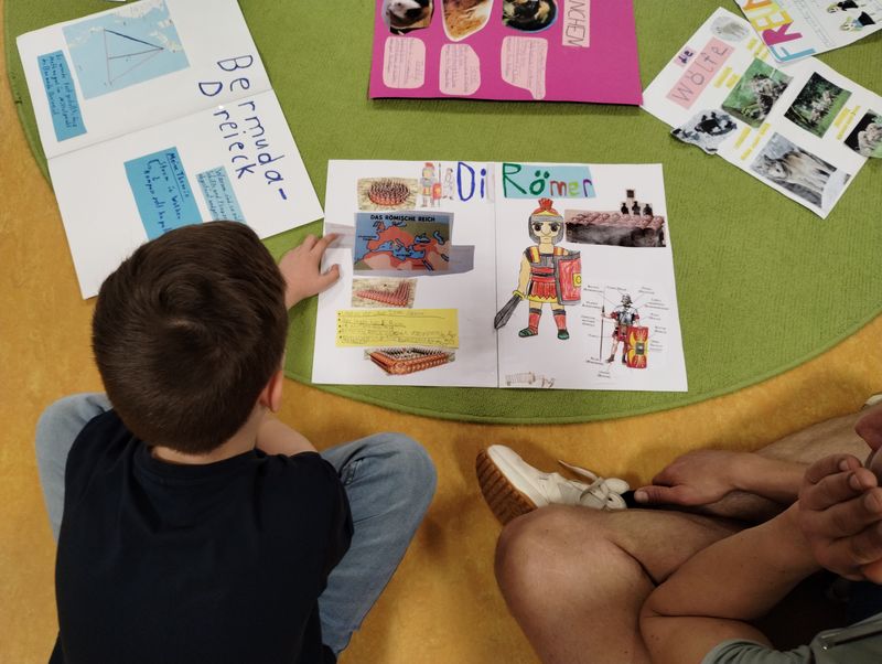 Die Schüler*innen zeigen stolz ihre gestalteten Plakate.